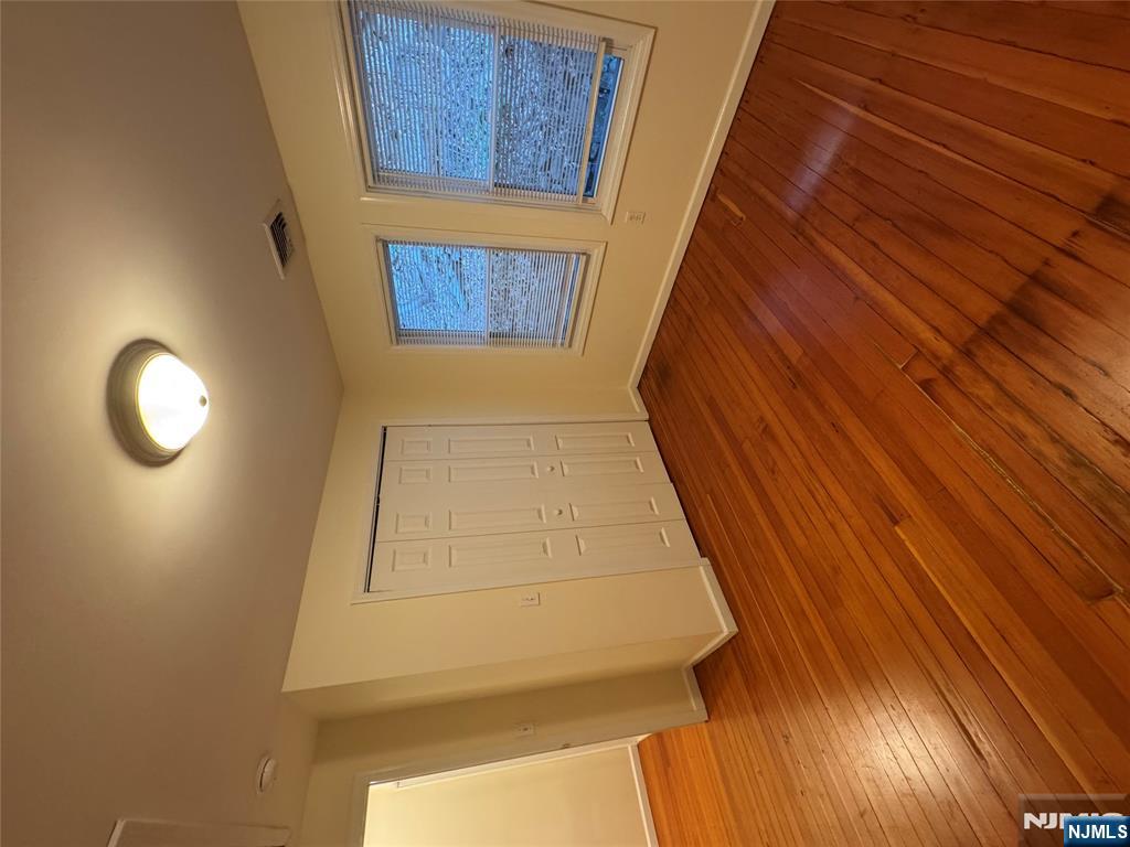 698 Undercliff Avenue Edgewater, NJ 07020 - Photo 8 of 10 an empty room with wooden floor and windows