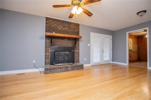 a view of an empty room with window and a fireplace