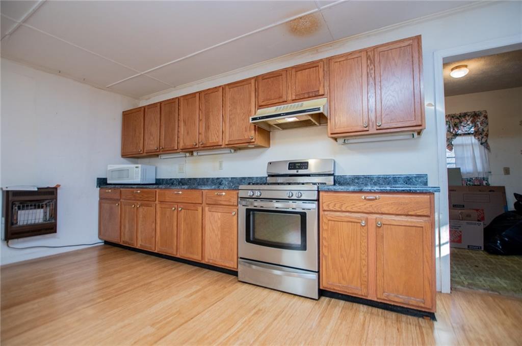 5166 Liberty Road Villa Rica, GA 30180 - Photo 24 of 52 a kitchen with granite countertop wooden cabinets stainless steel appliances and a wooden floor