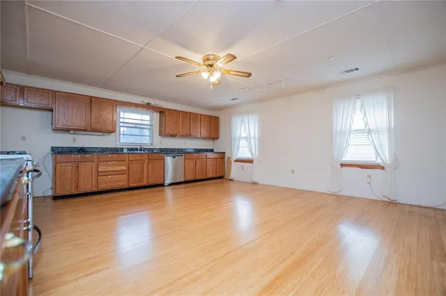 a view of an empty room with window and wooden floor