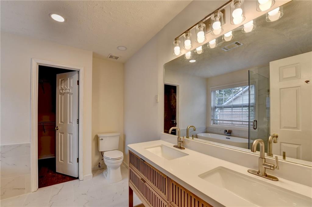 3555 Rivers End Place Buford, GA 30519 - Photo 26 of 49 a bathroom with a sink a toilet and a large mirror
