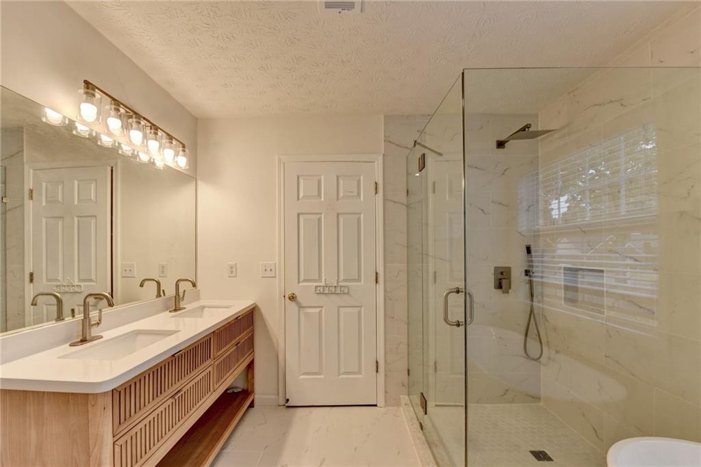 3555 Rivers End Place Buford, GA 30519 - Photo 28 of 49 a bathroom with a double vanity sink mirror and shower