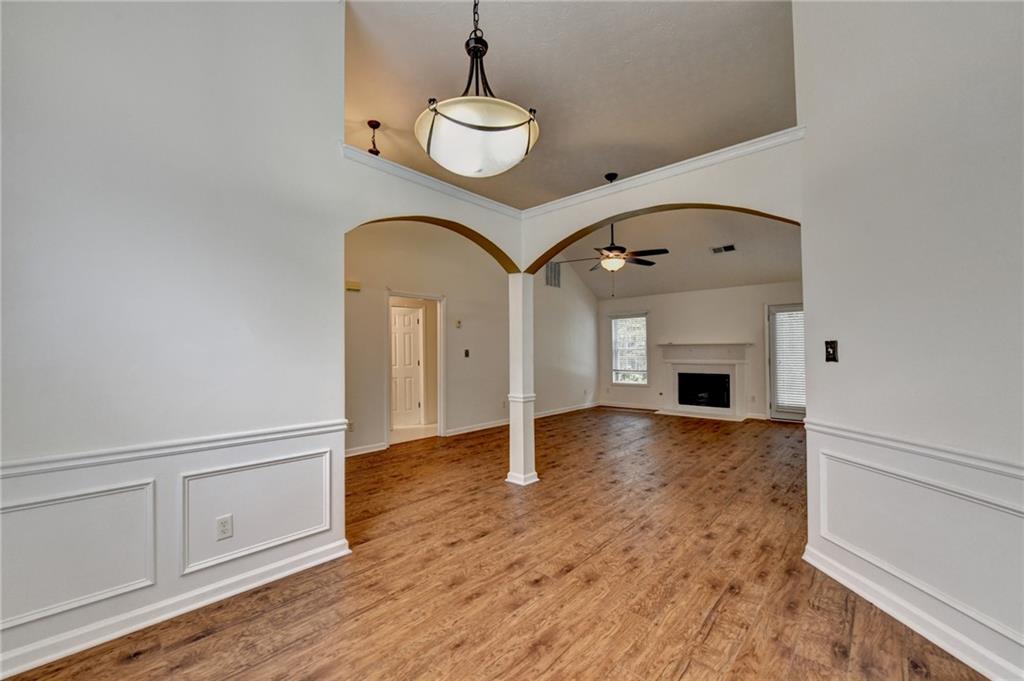 3555 Rivers End Place Buford, GA 30519 - Photo 8 of 49 an empty room with wooden floor fireplace and windows