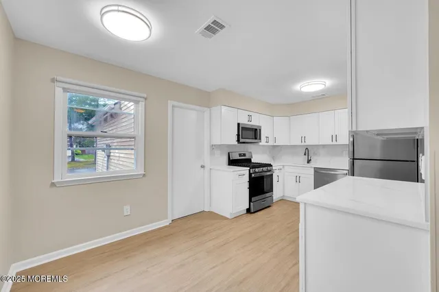 a kitchen with stainless steel appliances kitchen island wooden cabinets and refrigerator
