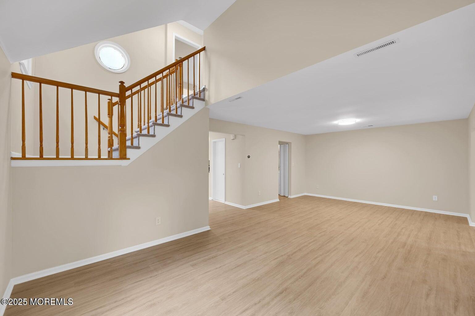 4 Cooper Court Freehold, NJ 07728 - Photo 3 of 23 a view of an empty room with wooden floor and stairs