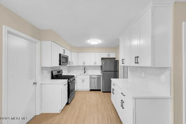 a open kitchen with cabinets microwave and refrigerator