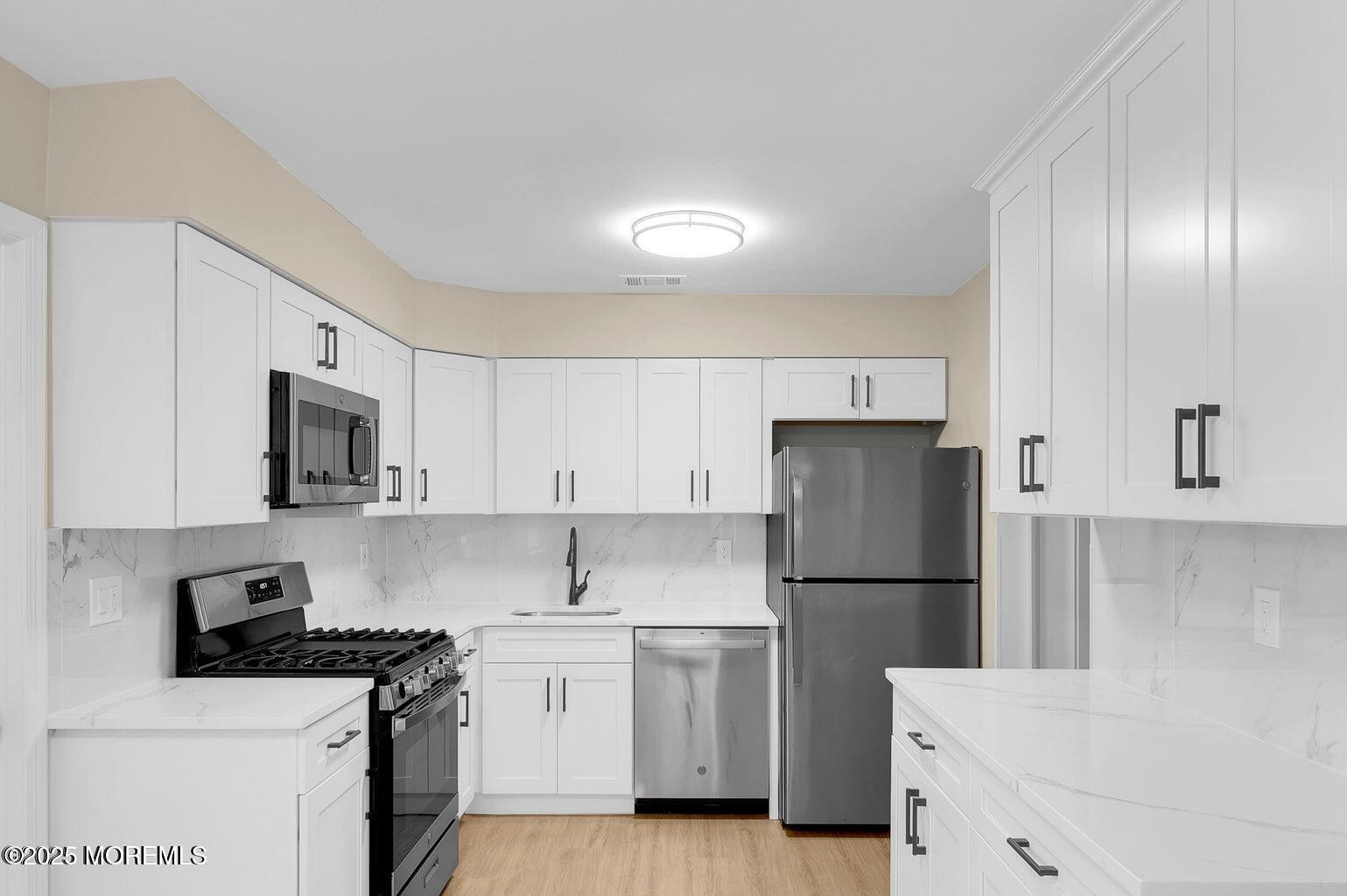 4 Cooper Court Freehold, NJ 07728 - Photo 10 of 23 a kitchen with a refrigerator sink and cabinets