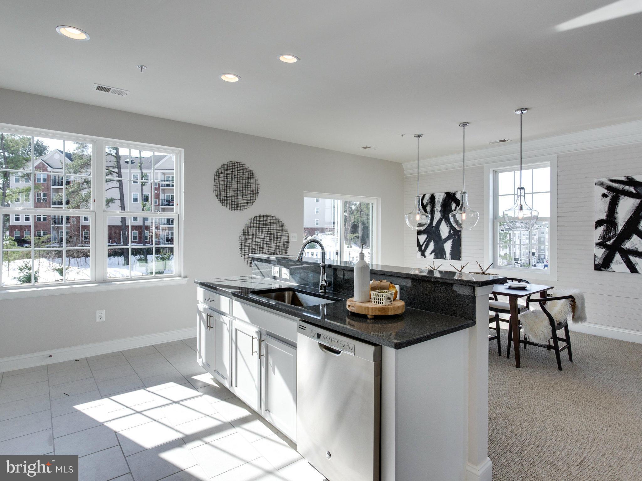1709 Fieldstone Court Hanover, MD 21076 - Photo 10 of 19 a kitchen with a stove a sink a dining table and chairs