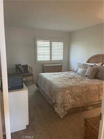 a bedroom with a bed and a refrigerator