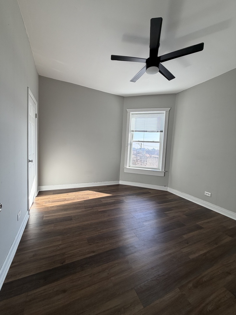 3339 West Adams Street, Unit 3E Chicago, IL 60624 - Photo 6 of 9 a view of an empty room with wooden floor and a window