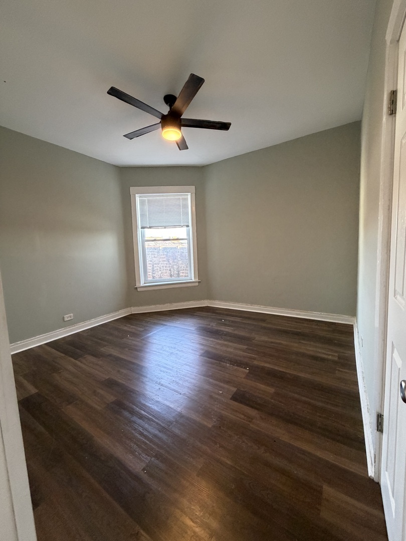3339 West Adams Street, Unit 3E Chicago, IL 60624 - Photo 7 of 9 an empty room with wooden floor and windows