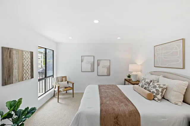 a bedroom with a bed and a large window