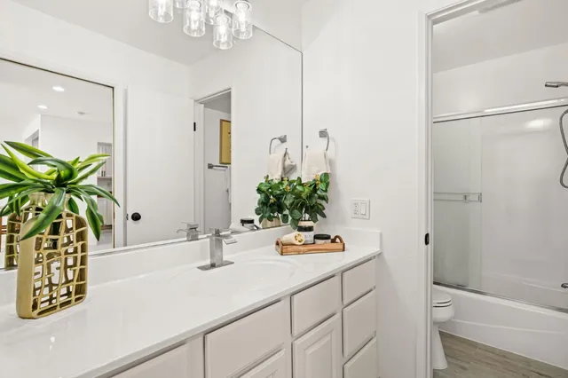 a bathroom with a sink a toilet and shower