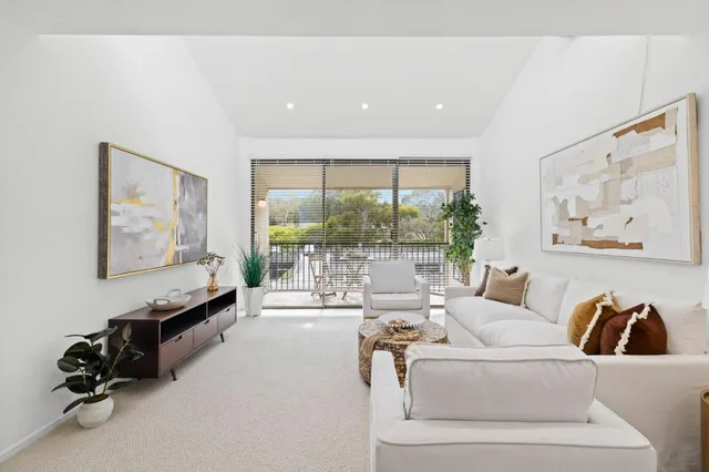 a living room with furniture and a large window with outer view