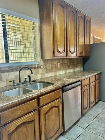 a kitchen with granite countertop a sink and cabinets