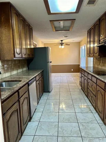 a kitchen with granite countertop a stove a sink and a microwave