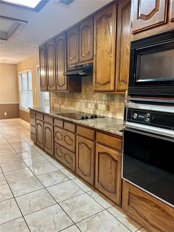 a kitchen with stainless steel appliances granite countertop a stove and a microwave