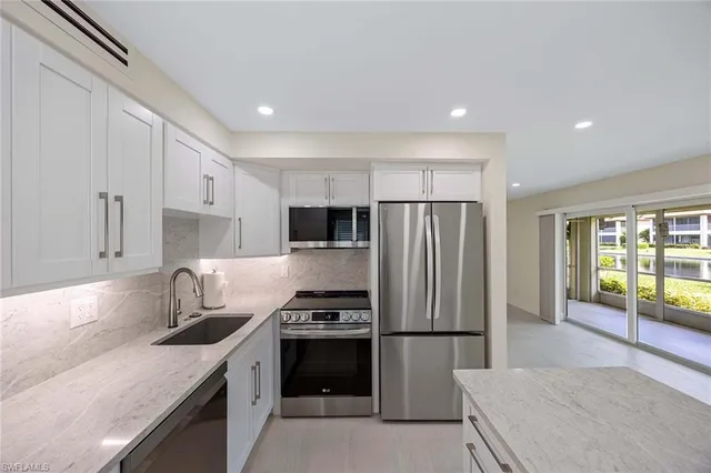 a kitchen with a refrigerator a sink and a stove top oven