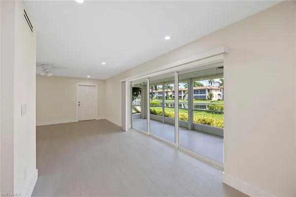 an empty room with a ceiling fan & entryway