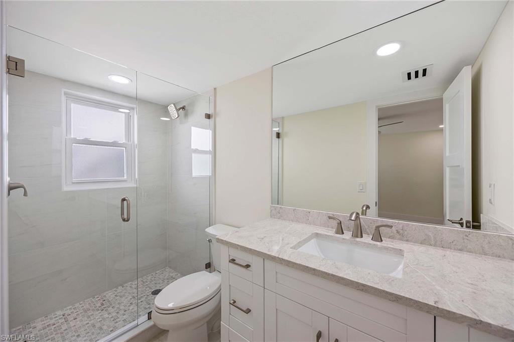 1155 Sandpiper Street, Unit F7 Naples, FL 34102 - Photo 15 of 29 a bathroom with a granite countertop sink a toilet and shower