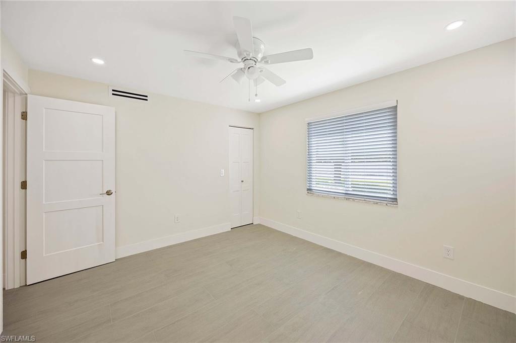 1155 Sandpiper Street, Unit F7 Naples, FL 34102 - Photo 16 of 29 an empty room with a ceiling fan and windows