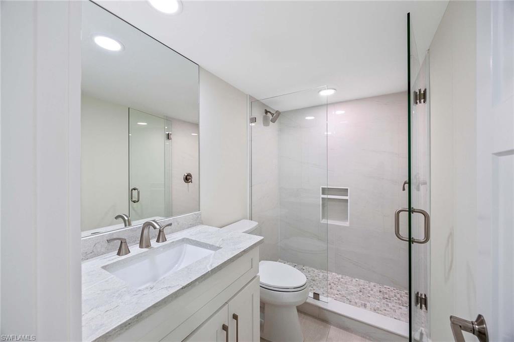1155 Sandpiper Street, Unit F7 Naples, FL 34102 - Photo 17 of 29 a bathroom with a granite countertop sink toilet and shower