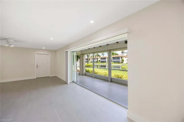 en empty room with wooden floor and windows