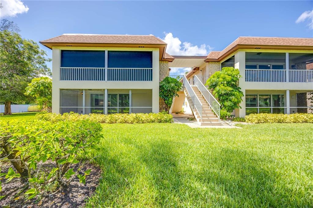 1155 Sandpiper Street, Unit F7 Naples, FL 34102 - Photo 4 of 29 a front view of a house with a yard