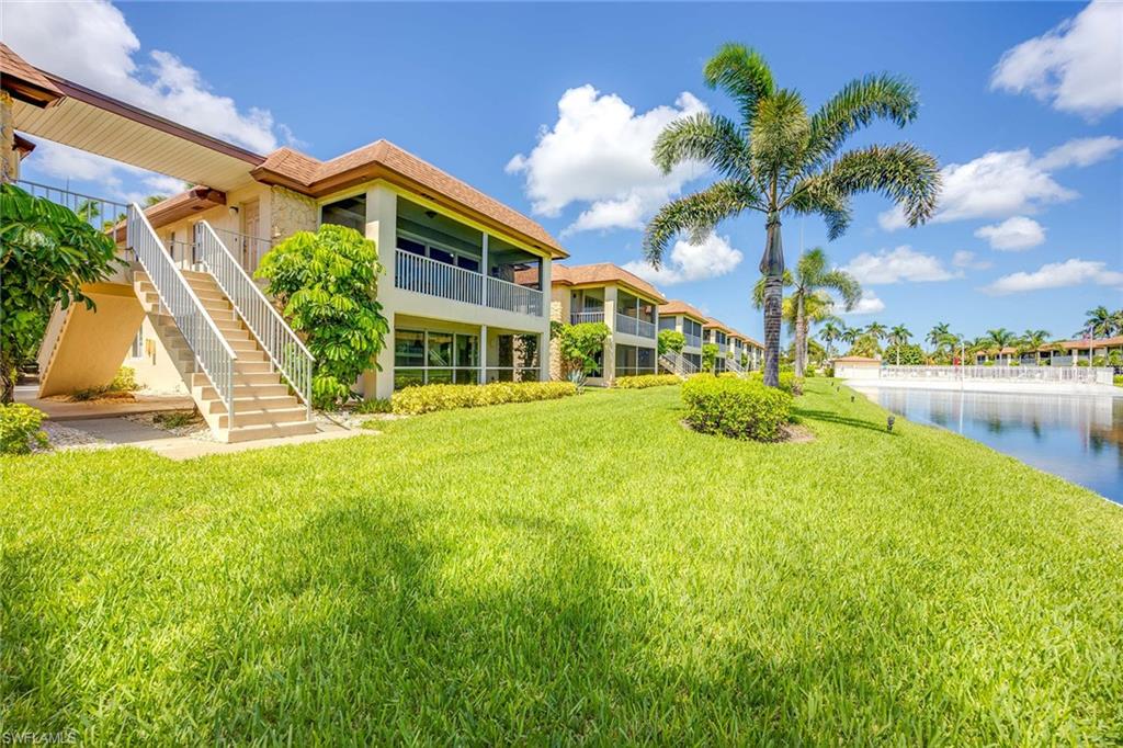 1155 Sandpiper Street, Unit F7 Naples, FL 34102 - Photo 5 of 29 a front view of a house with a yard and lake view