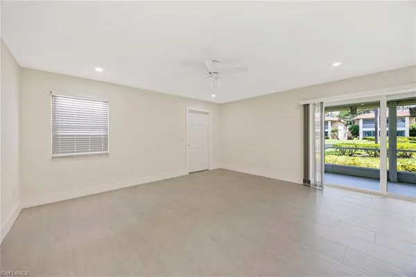 an empty room with ceiling fan and window