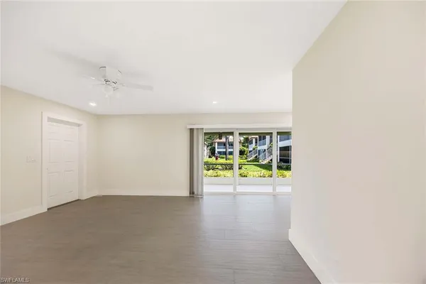 an empty room with windows and ceiling fan