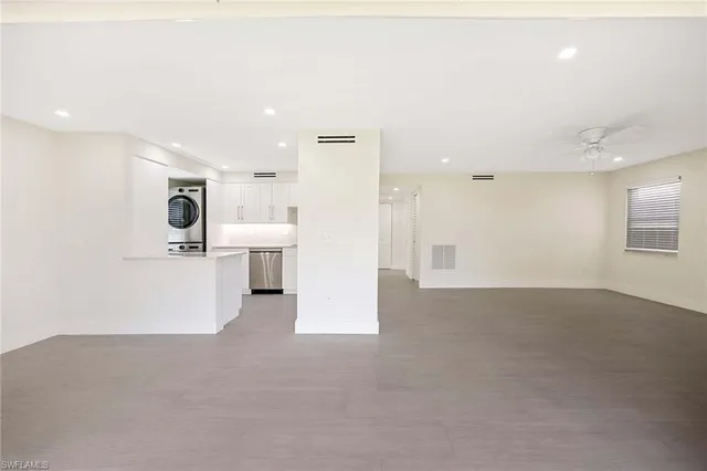 an empty room with a ceiling fan and a window
