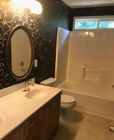 a bathroom with a sink mirror vanity and toilet