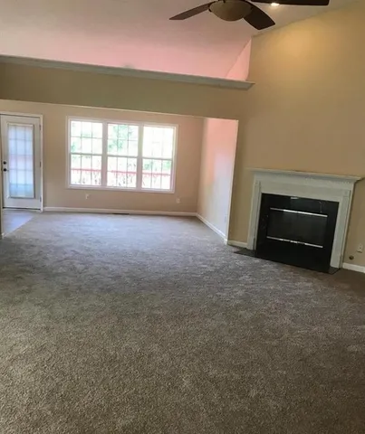 an empty room with a fireplace and windows