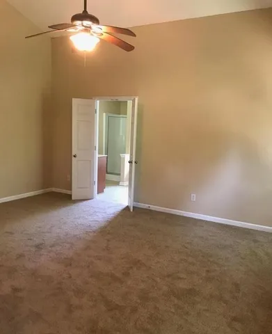 en empty room with windows and ceiling fan