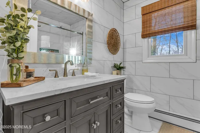 a bathroom with a granite countertop sink a toilet and a mirror