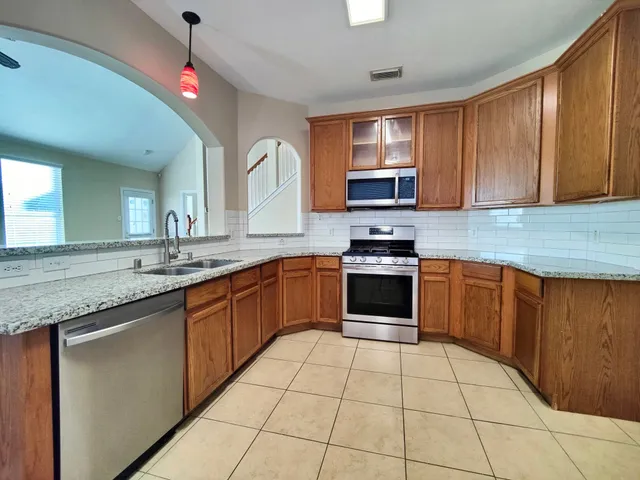 a kitchen with stainless steel appliances granite countertop a stove sink and cabinets