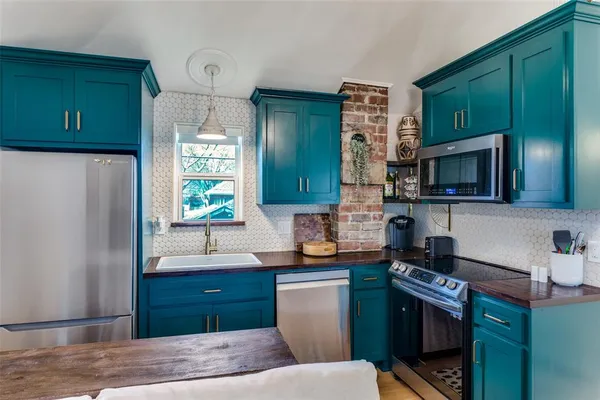 a kitchen with stainless steel appliances granite countertop a refrigerator stove and sink