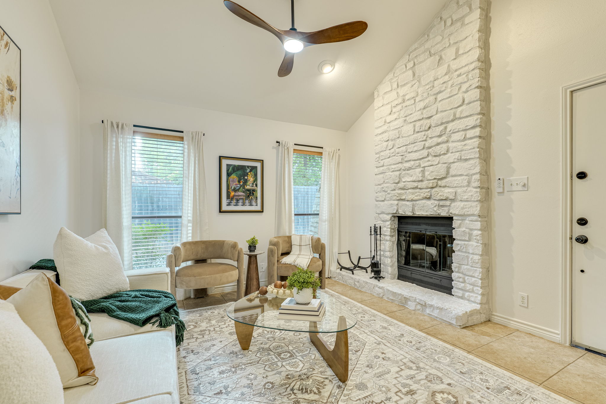 2500 Enfield Road, Unit 9 Austin, TX 78703 - Photo 26 of 26 Living area featuring a floor-to-ceiling white stone fireplace with a black firebox, vaulted ceiling, and a modern ceiling fan