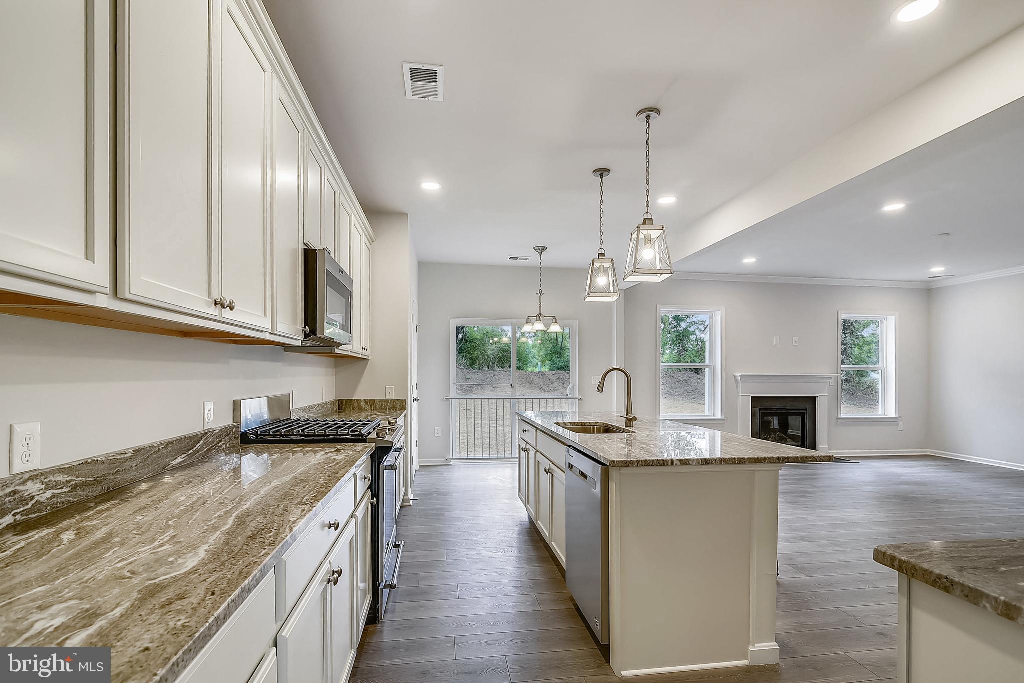 13814 Pecan Ridge Way Bowie, MD 20715 - Photo 5 of 14 a kitchen with stainless steel appliances kitchen island granite countertop a stove top oven a sink dishwasher and a microwave with wooden floor
