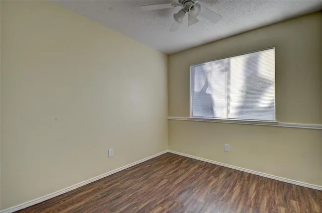 a view of a room that has a window and wooden floor