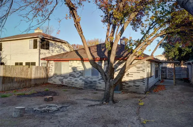 a backyard of a house with barbeque oven and wooden fence