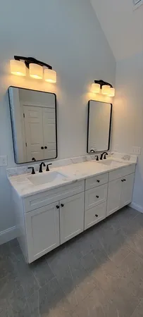 a bathroom with a double vanity sink and mirror