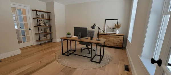 a view of a workspace with furniture and wooden floor