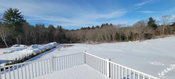 a view of a yard with wooden fence