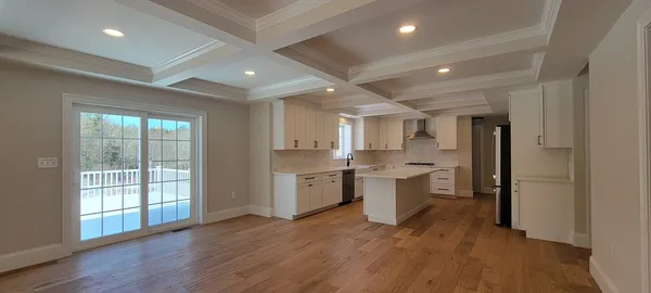 a large kitchen with a large counter top space a sink stainless steel appliances and cabinets