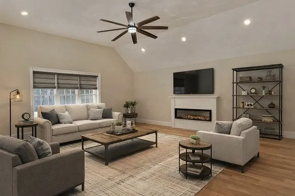 a living room with furniture a flat screen tv and a fireplace