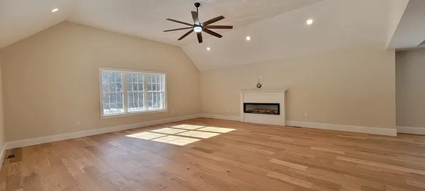 an empty room with windows and ceiling fan