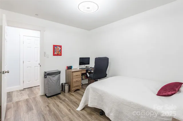 a bedroom with a bed and wooden floor