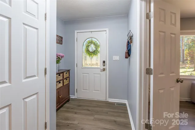 a view of hallway with wooden floor and a dining room